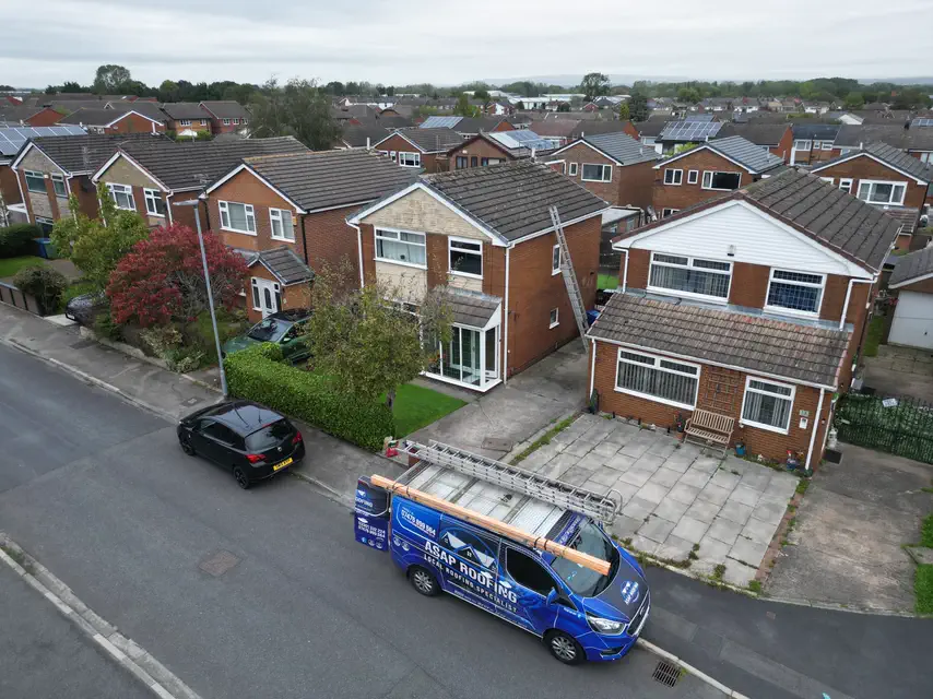 Aerial view of a street of semi-detached houses, with the ASAP Roofing van parked outside and ladders up