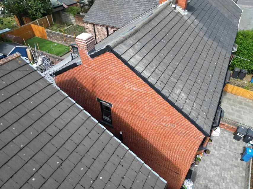 Grey tiled roof on a red-brick end terrace, seen from the air