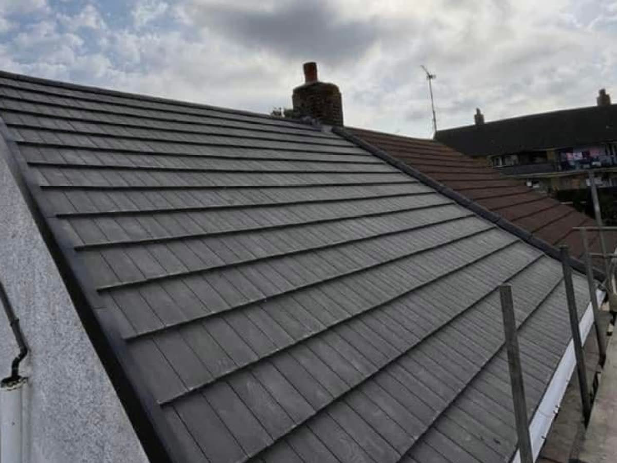 The same roof re-covered in new grey tiles with a neat edge along the gable