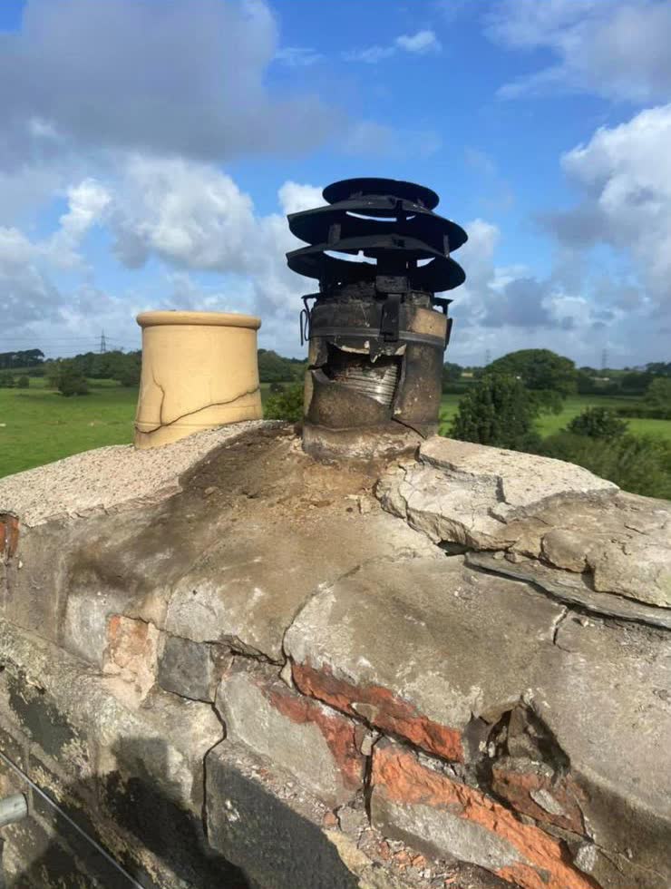 A weathered chimney stack with a black cowl, before the work