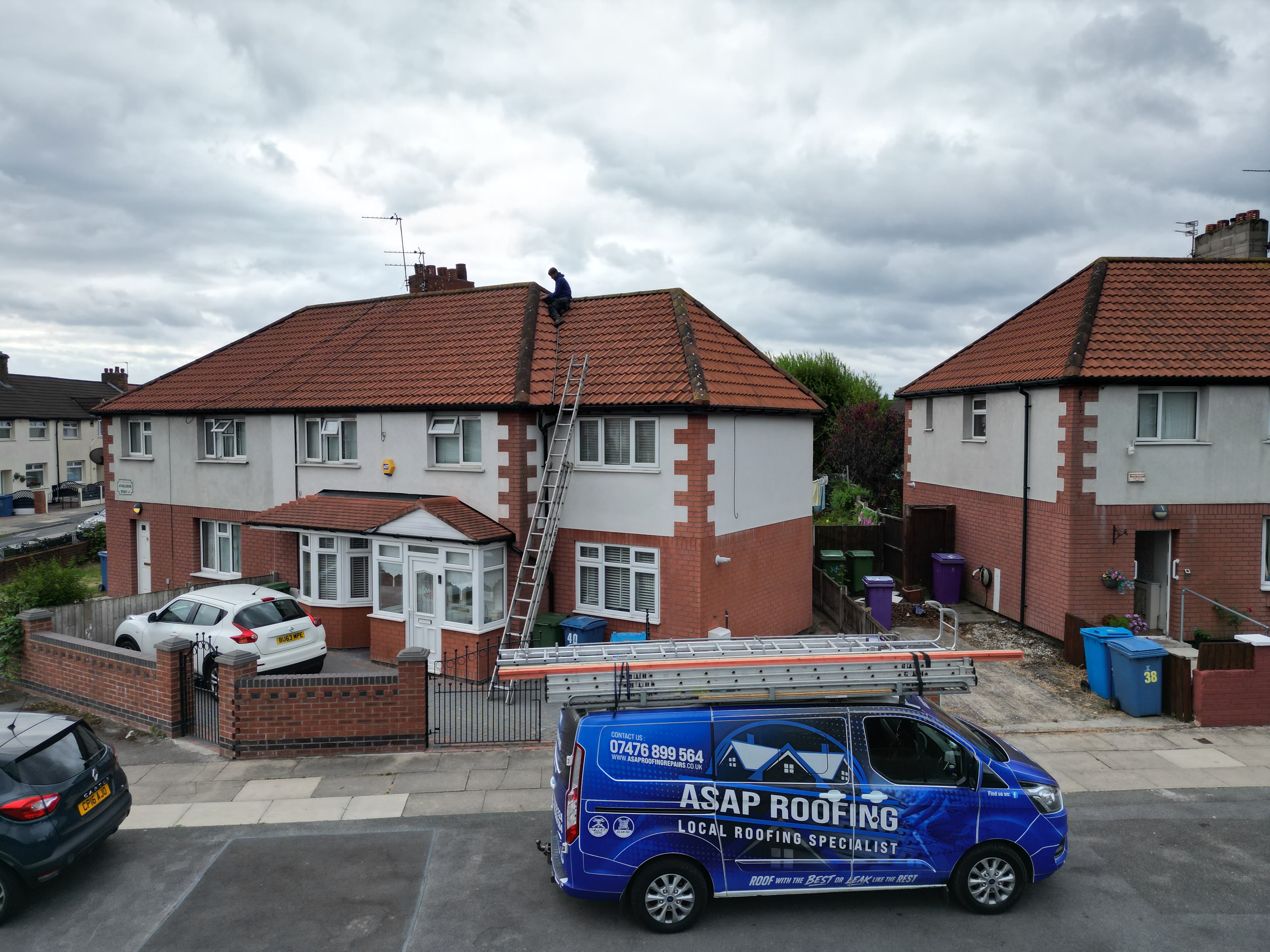 Roofer on a semi-detached roof, with the ASAP Roofing van parked outside