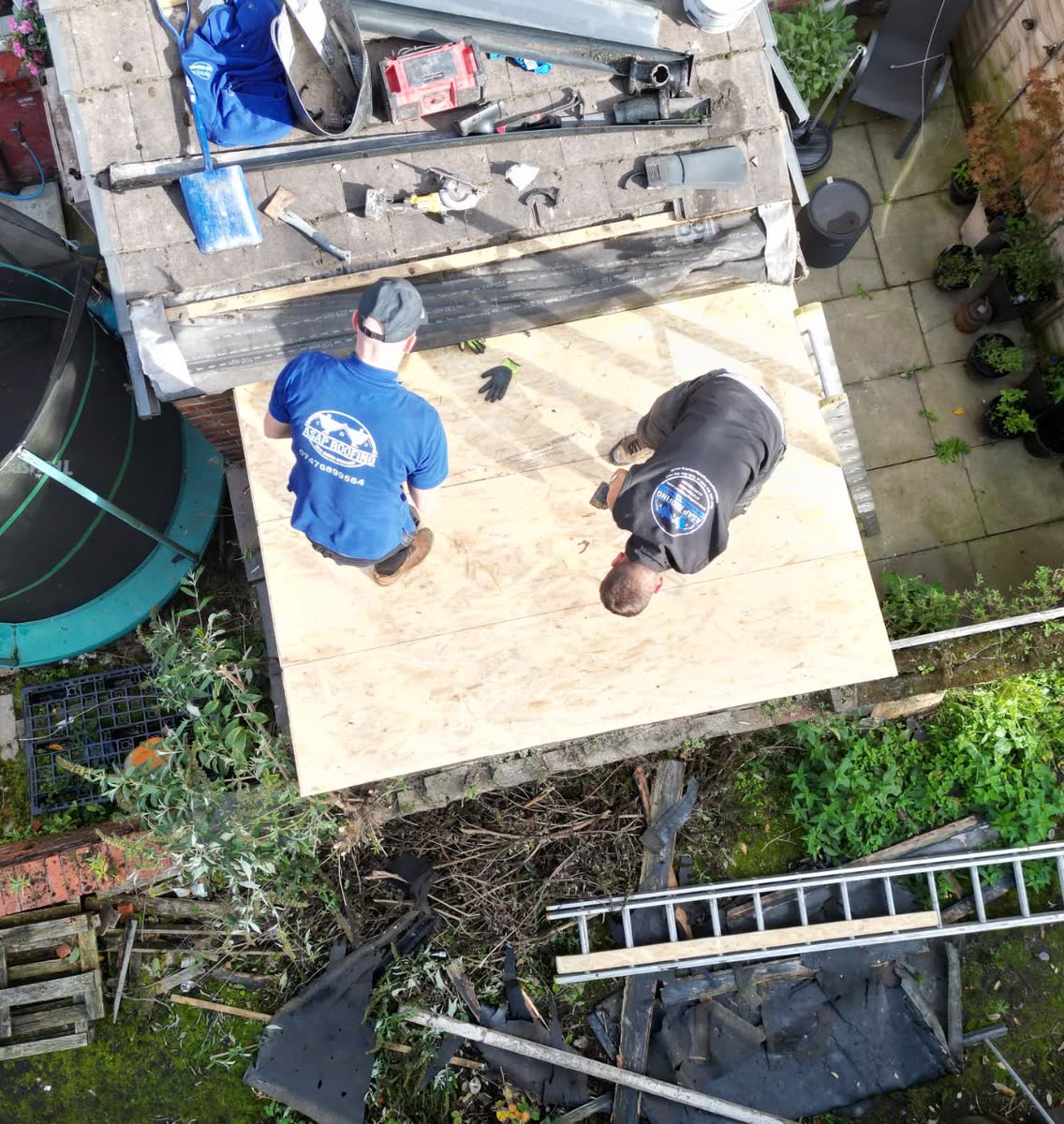 Two of the ASAP Roofing team laying a new timber deck for a flat roof