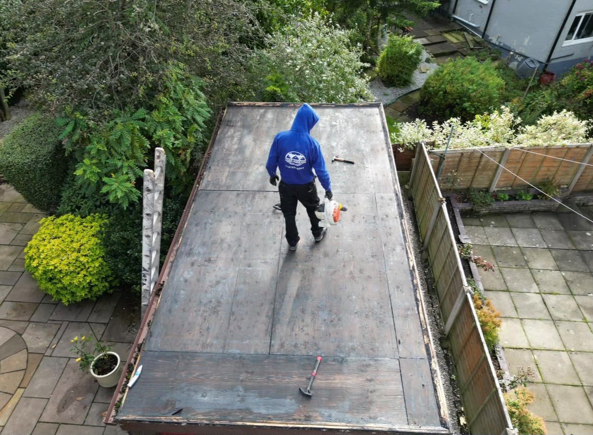 One of the ASAP Roofing team on a long flat roof at the back of a house