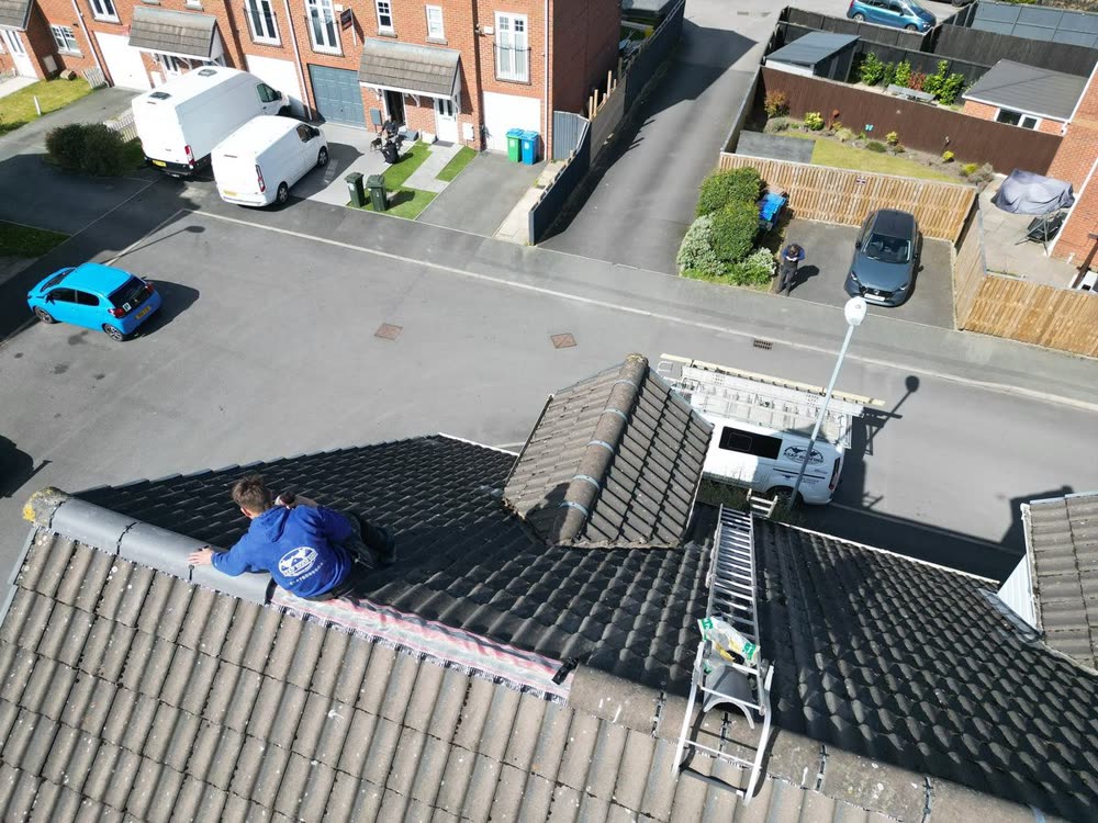 Roofer repairing a concrete tiled roof